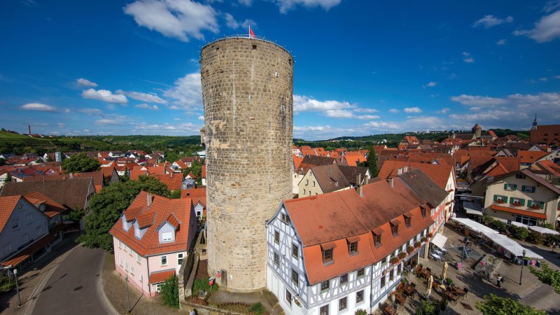 Luftaufnahme des Waldhornturms in Besigheim, umgeben von roten Dächern und Fachwerkhäusern unter blauem Himmel mit weißen Wolken., © Stuttgart-Marketing GmbH, Achim Mende Luftaufnahme des Waldhornturms in Besigheim, umgeben von roten Dächern und Fachwerkhäusern unter blauem Himmel mit weißen Wolken., © Stuttgart-Marketing GmbH, Achim Mende