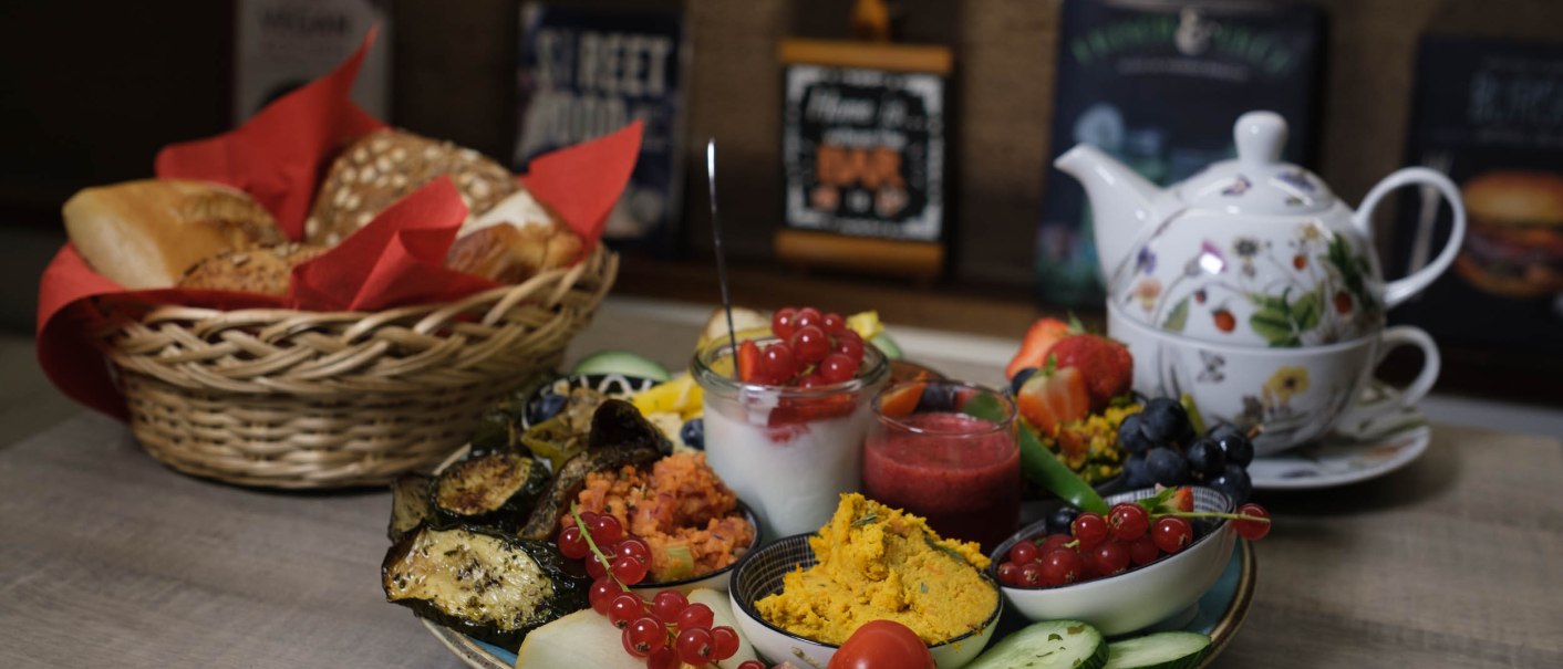 Ein reichhaltiges Fr&uuml;hst&uuml;ck mit frischem Obst, Gem&uuml;se, Dips und Brot. Eine Teekanne mit Tassen steht bereit., &copy; ZentralBar