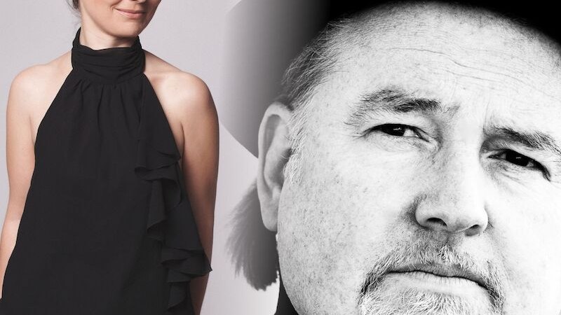 Frau in schwarzem Top lächelt, neben ihr ein Schwarz-Weiß-Porträt eines Mannes mit Hut. Kontrast zwischen Farbe und Schwarz-Weiß., © Mauerwerk GmbH Frau in schwarzem Top lächelt, neben ihr ein Schwarz-Weiß-Porträt eines Mannes mit Hut. Kontrast zwischen Farbe und Schwarz-Weiß., © Mauerwerk GmbH