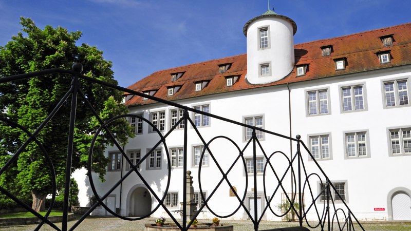 Schloss Waldenbuch mit wei&szlig;er Fassade und rotem Dach, umgeben von B&auml;umen. Ein schmiedeeisernes Gel&auml;nder im Vordergrund., &copy; Gert-Peter Albig, GDA Waldenbuch