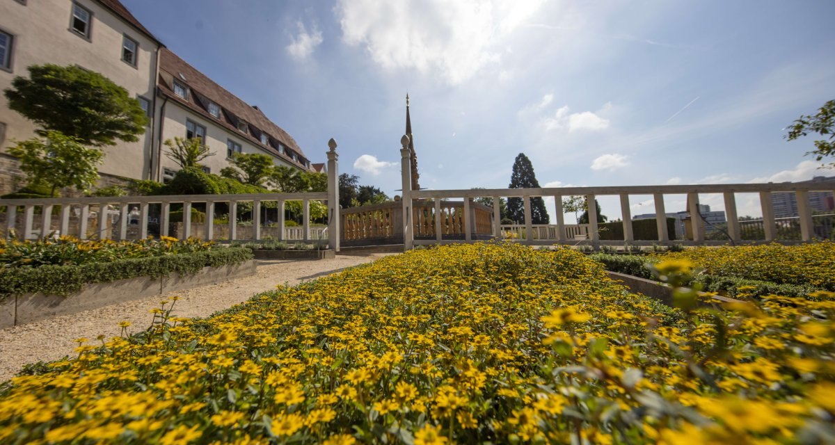 Gelbe Blumen bl&uuml;hen in einem gepflegten Garten vor einem historischen Geb&auml;ude. Der Himmel ist blau mit einigen Wolken., &copy; Stuttgart Marketing GmbH Achim Mende