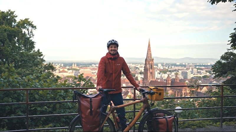 Eine Person mit Helm posiert mit einem Fahrrad vor der Skyline von Freiburg im Breisgau, mit dem M&uuml;nster im Hintergrund., &copy; Kulturhaus Schwanen