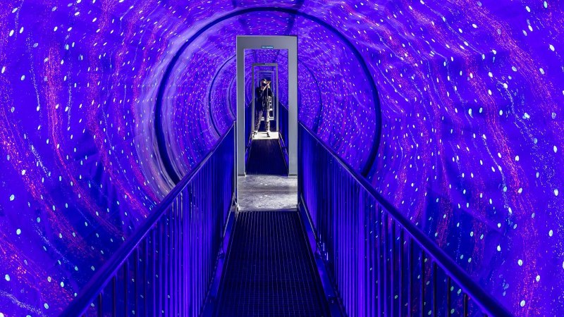 Ein beleuchteter Tunnel mit blauen und violetten Lichtern im Museum der Illusionen Stuttgart. Eine Person steht am Ende des Tunnels., © Stuttgart-Marketing GmbH, Sarah Schmid Ein beleuchteter Tunnel mit blauen und violetten Lichtern im Museum der Illusionen Stuttgart. Eine Person steht am Ende des Tunnels., © Stuttgart-Marketing GmbH, Sarah Schmid