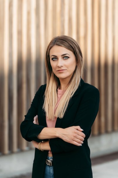Frau mit langen blonden Haaren und schwarzem Blazer steht selbstbewusst vor einer Holzwand., &copy; Dieselstrasse Kulturzentrum e.V.