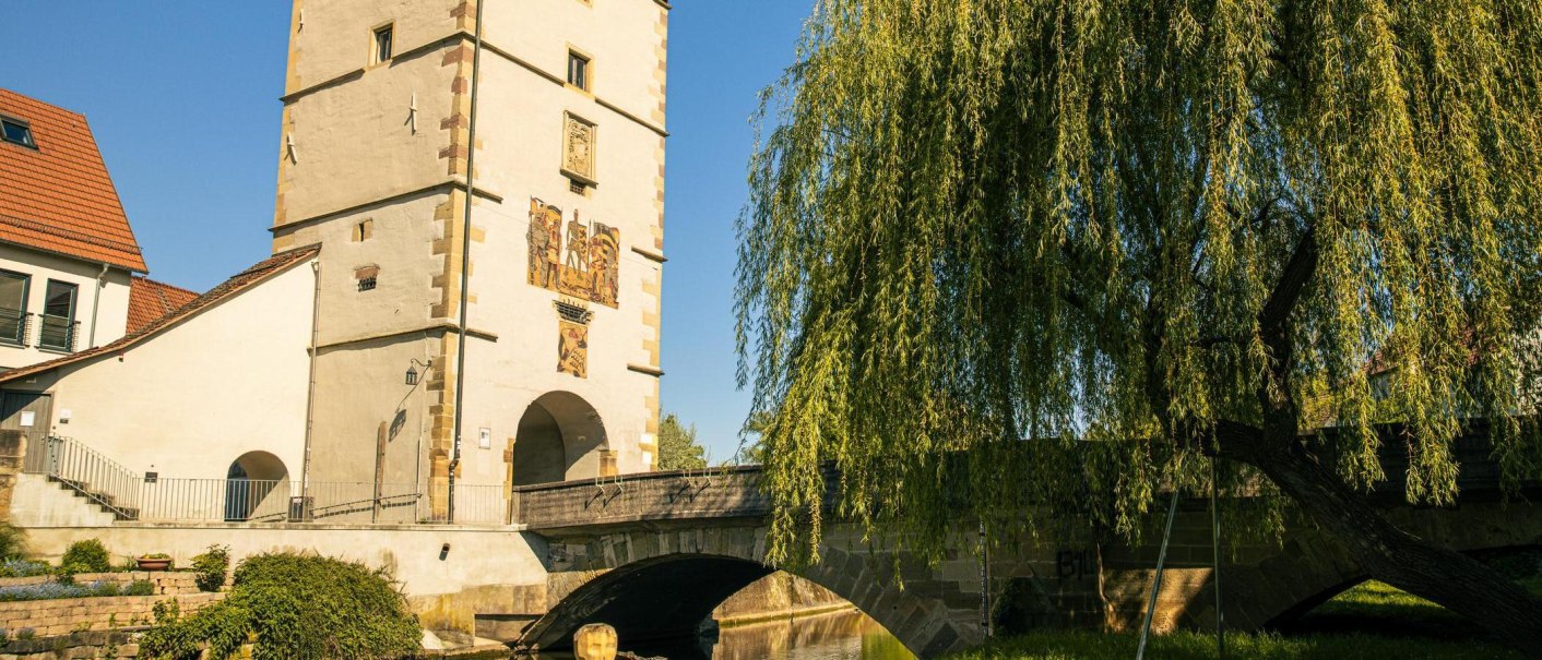 Das Beinsteiner Tor in Waiblingen, flankiert von einer Brücke und einem großen Baum, bei strahlend blauem Himmel., © Stuttgart-Marketing GmbH, Sarah Schmid