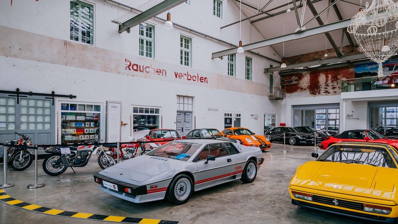 Innenansicht der Motorworld Region Stuttgart mit klassischen Autos und Motorrädern in einer Halle mit hohen Decken und einem Kronleuchter., © Stuttgart-Marketing GmbH, Thomas Niedermüller