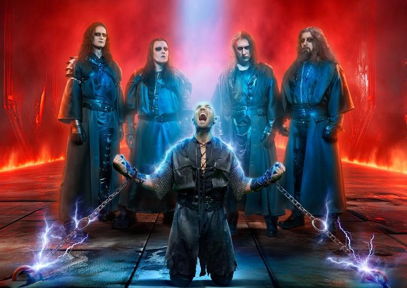 F&uuml;nf M&auml;nner in dunkler Kleidung, einer kniet mit erhobenen Armen und Ketten. Dramatische Beleuchtung in Rot und Blau., &copy; Music Circus Concertb&uuml;ro GmbH & Co. KG