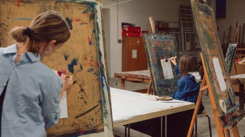 Zwei Erwachsene malen an Staffeleien in einem Kunstworkshop. Der Raum ist mit Malutensilien ausgestattet., © Kunstschule Labyrinth Zwei Erwachsene malen an Staffeleien in einem Kunstworkshop. Der Raum ist mit Malutensilien ausgestattet., © Kunstschule Labyrinth