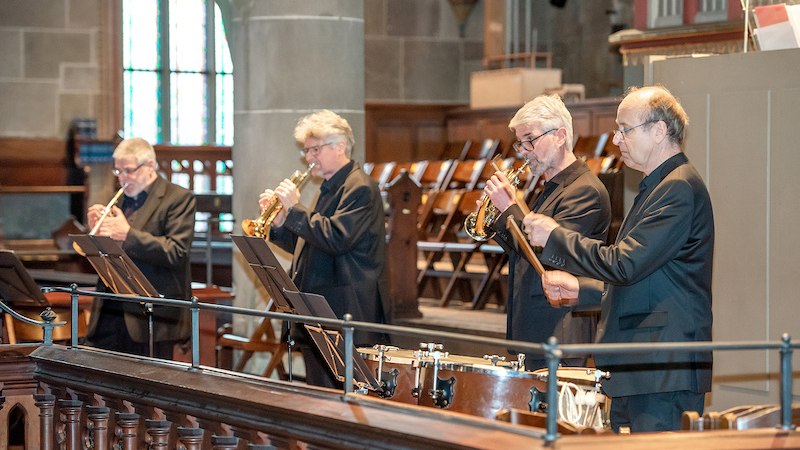 Vier Musiker in einer Kirche spielen Trompeten und Pauken. Sie tragen schwarze Anzüge und stehen vor Notenständern. Im Hintergrund sind Kirchenbänke zu sehen., © Konzertbüro Joachim Jung Vier Musiker in einer Kirche spielen Trompeten und Pauken. Sie tragen schwarze Anzüge und stehen vor Notenständern. Im Hintergrund sind Kirchenbänke zu sehen., © Konzertbüro Joachim Jung