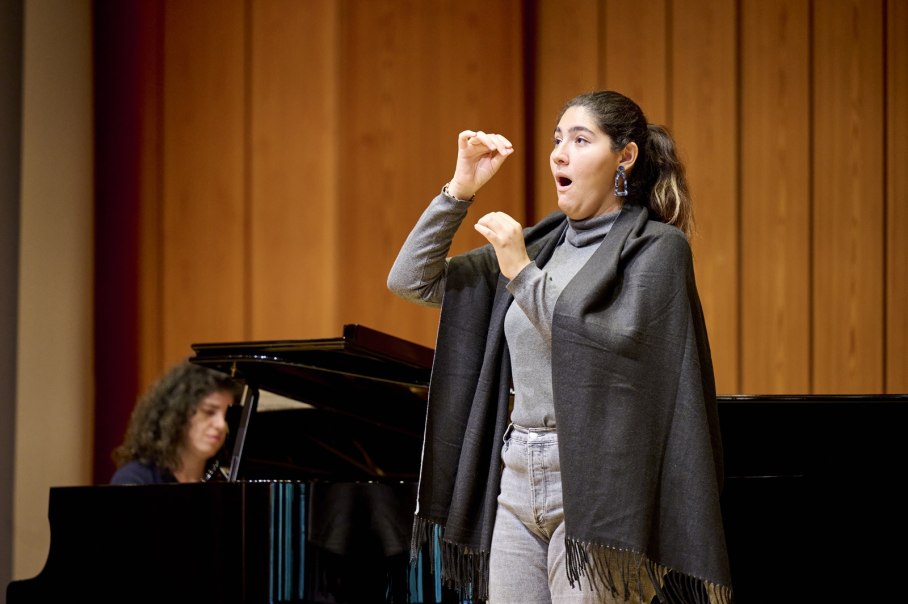 Eine Frau singt leidenschaftlich auf einer B&uuml;hne, w&auml;hrend eine Pianistin im Hintergrund spielt. Der Raum hat eine h&ouml;lzerne Wandverkleidung., &copy; www.peter-oppenlaender.de
