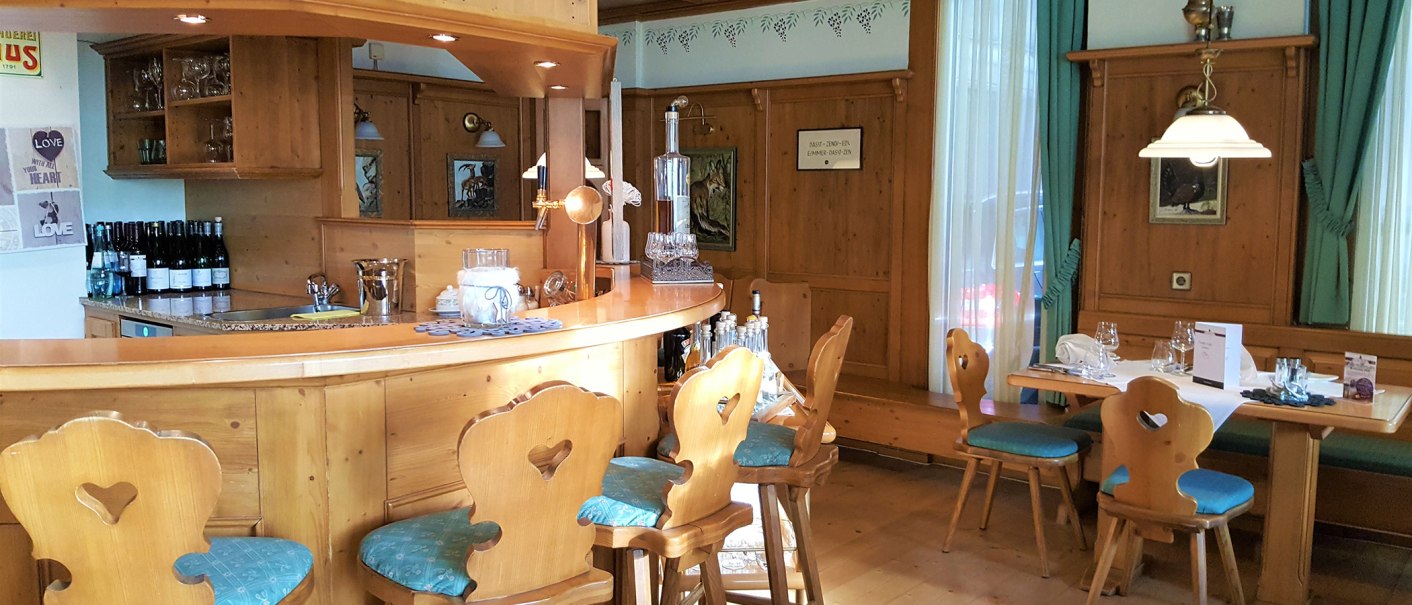 Holzvertäfelte Bar mit rustikalen Stühlen und Tisch im Erikson Hotel. Dekorative Bilder und Flaschen auf der Theke, gemütliche Atmosphäre., © Erikson Hotel Sindelfingen Holzvertäfelte Bar mit rustikalen Stühlen und Tisch im Erikson Hotel. Dekorative Bilder und Flaschen auf der Theke, gemütliche Atmosphäre., © Erikson Hotel Sindelfingen