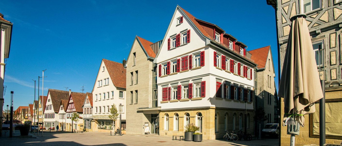 Historische Gebäude am Marktplatz von Marbach am Neckar unter klarem, blauem Himmel. Die Fassaden sind mit roten Fensterläden verziert., © Stuttgart-Marketing GmbH, Sarah Schmid