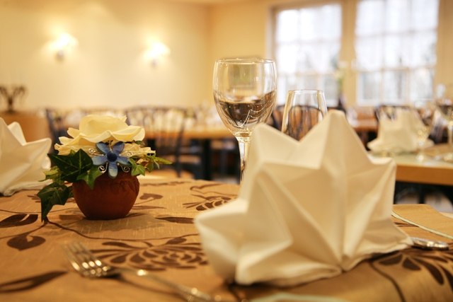 Ein elegant gedeckter Tisch in einem Restaurant mit gefalteter Serviette, Weinglas und Blumendekoration., © ateckhotel Ein elegant gedeckter Tisch in einem Restaurant mit gefalteter Serviette, Weinglas und Blumendekoration., © ateckhotel