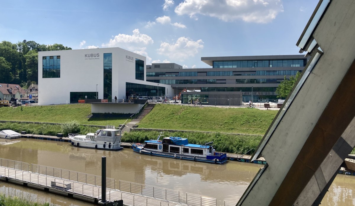 Moderne Gebäude am Flussufer in Remseck am Neckar, mit Booten im Wasser und einem klaren Himmel im Hintergrund., © Remstal Tourismus e. V.