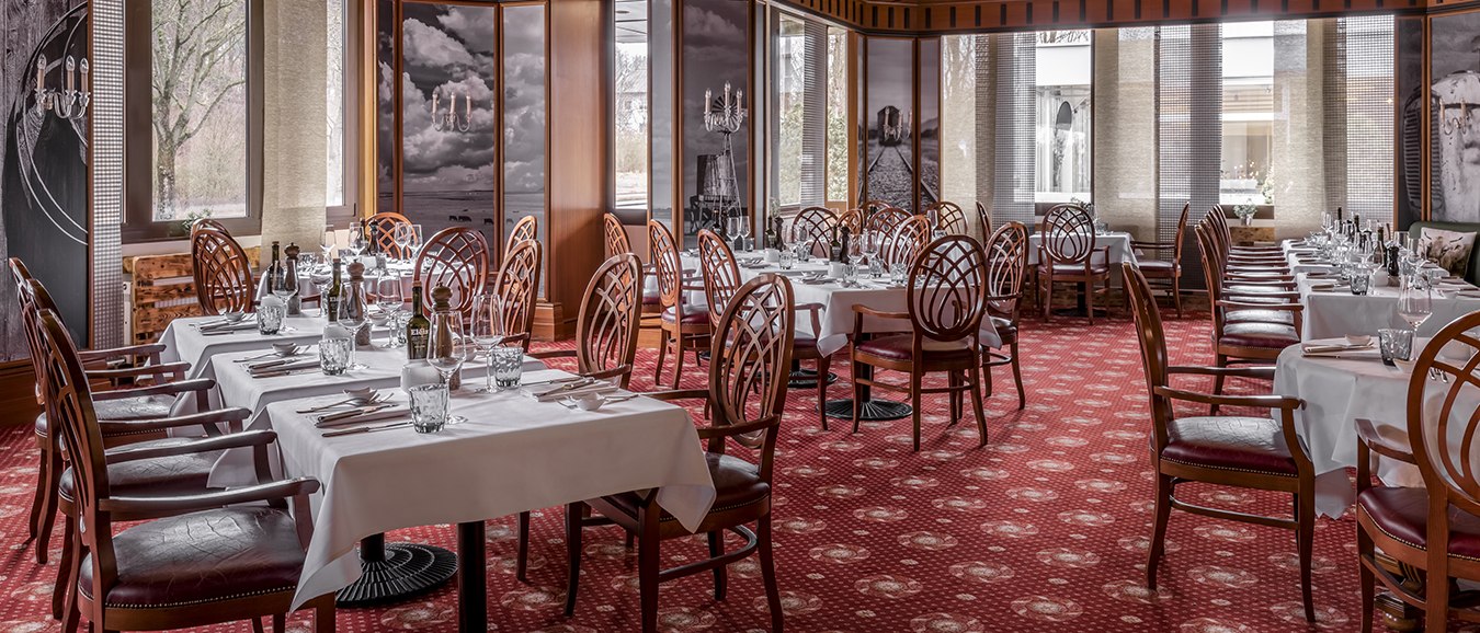 Elegantes Restaurant mit weißen Tischdecken, Holzstühlen und rotem Teppich. Große Fenster und dekorative Wandbilder schaffen eine stilvolle Atmosphäre., © Stuttgart Marriott Hotel Sindelfingen