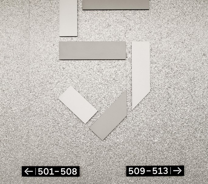 Graue Wand mit stilisierter Zahl 5. Schilder zeigen Zimmernummern: 501-508 links, 509-513 rechts, 514-518 links., © Hotel am Remspark Graue Wand mit stilisierter Zahl 5. Schilder zeigen Zimmernummern: 501-508 links, 509-513 rechts, 514-518 links., © Hotel am Remspark