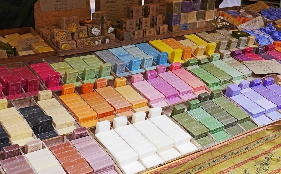 Bunte Seifenstücke sind auf einem Marktstand in verschiedenen Farben und Formen ausgestellt. Der Stand ist reichhaltig bestückt und wirkt einladend. Bunte Seifenstücke sind auf einem Marktstand in verschiedenen Farben und Formen ausgestellt. Der Stand ist reichhaltig bestückt und wirkt einladend.