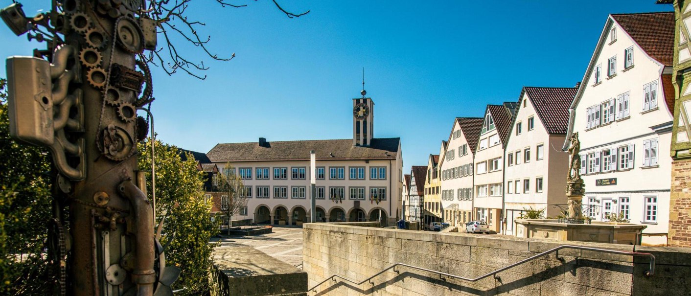 Der Marktplatz in B&ouml;blingen zeigt historische Geb&auml;ude und eine kunstvolle Skulptur im Vordergrund unter einem klaren blauen Himmel., &copy; Stuttgart-Marketing GmbH, Sarah Schmid