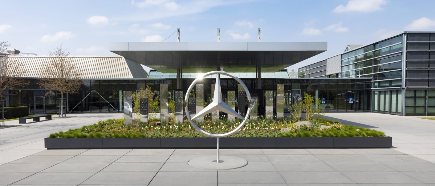 Das Mercedes-Benz Kundencenter mit einem großen Mercedes-Logo im Vordergrund, umgeben von moderner Architektur und Pflanzen., © Mercedes-Benz Kundencenter Das Mercedes-Benz Kundencenter mit einem großen Mercedes-Logo im Vordergrund, umgeben von moderner Architektur und Pflanzen., © Mercedes-Benz Kundencenter