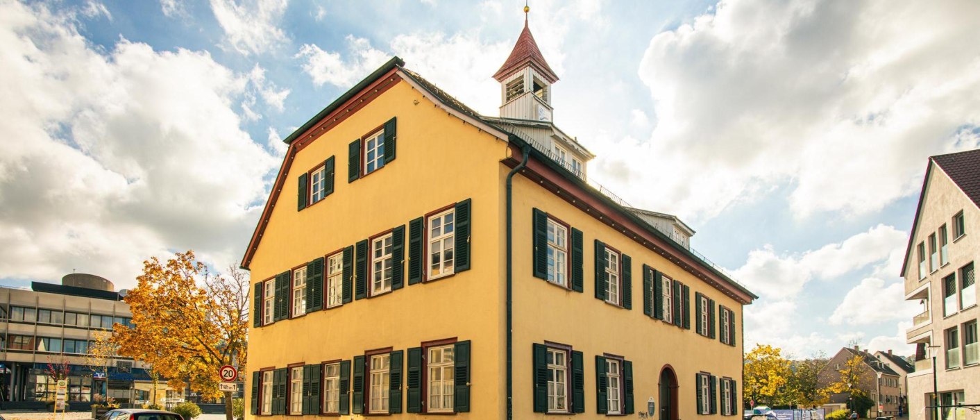 Historisches Geb&auml;ude in Gerlingen mit gelber Fassade und gr&uuml;nen Fensterl&auml;den. Der Himmel ist blau mit einigen Wolken., &copy; SMG, Sarah Schmid