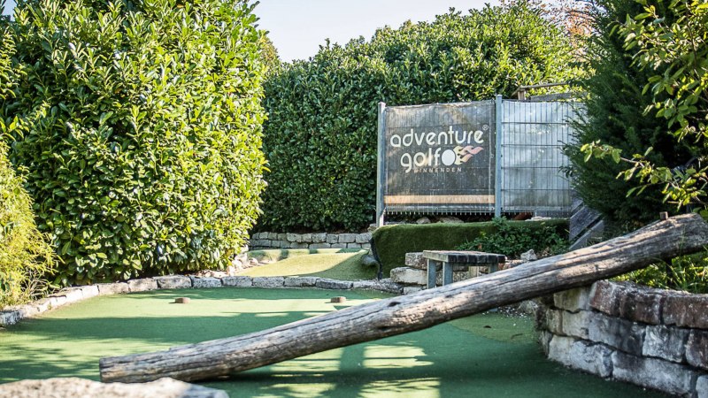 Adventure-Golfanlage in Winnenden mit grünem Kunstrasen und Holzhindernis, umgeben von üppigem Grün., © Adventuregolf Winnenden Adventure-Golfanlage in Winnenden mit grünem Kunstrasen und Holzhindernis, umgeben von üppigem Grün., © Adventuregolf Winnenden