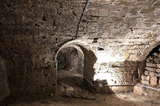 Ein steinerner Gew&ouml;lbekeller mit einem beleuchteten Durchgang. Die W&auml;nde und Decke bestehen aus grobem Mauerwerk., &copy; Eigenbetrieb Tourismus und Citymanagement Schorndorf