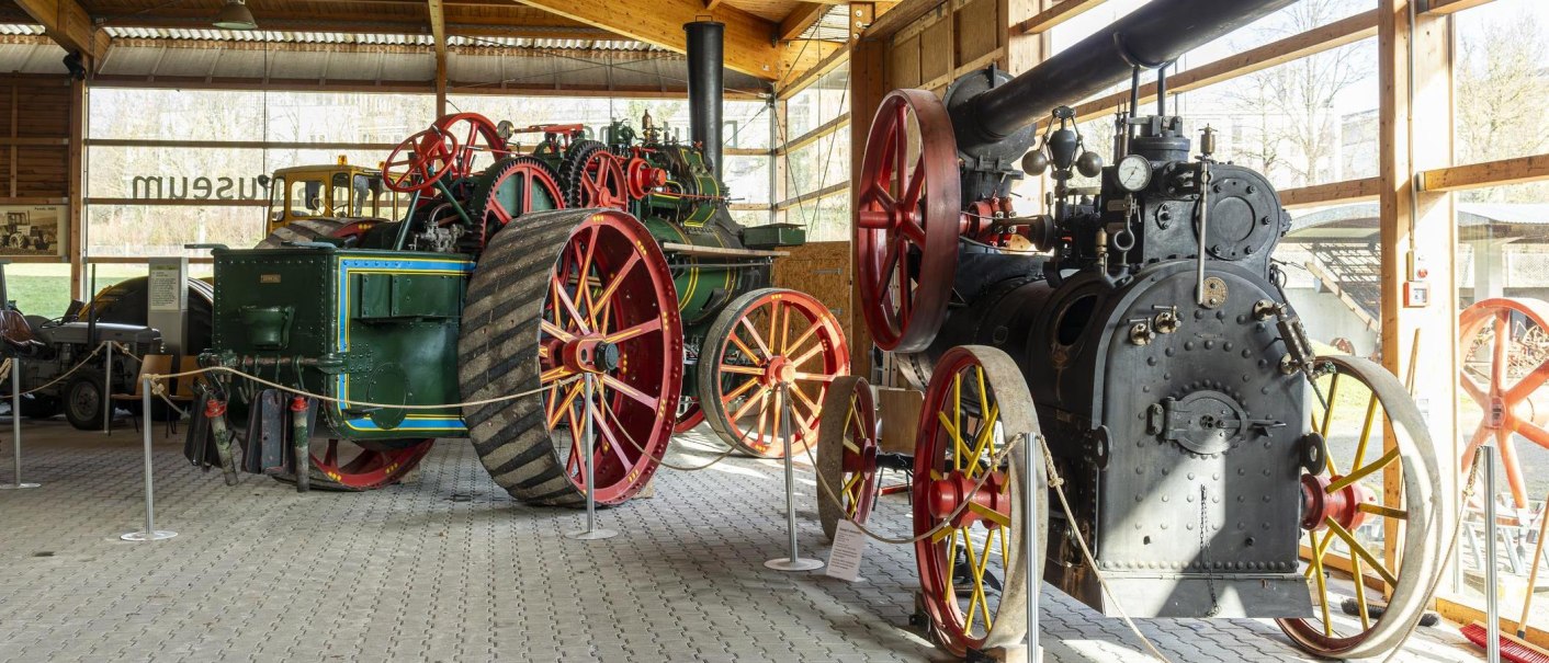 Historische Traktoren und Maschinen im Deutschen Landwirtschaftsmuseum, ausgestellt in einer Halle mit großen Fenstern., © SMG, Sarah Schmid