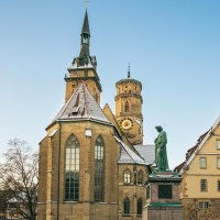 Die Stiftskirche in Stuttgart mit schneebedecktem Dach und einer Statue im Vordergrund. Der Himmel ist klar und blau., &copy; Stuttgart-Marketing GmbH, Sarah Schmid