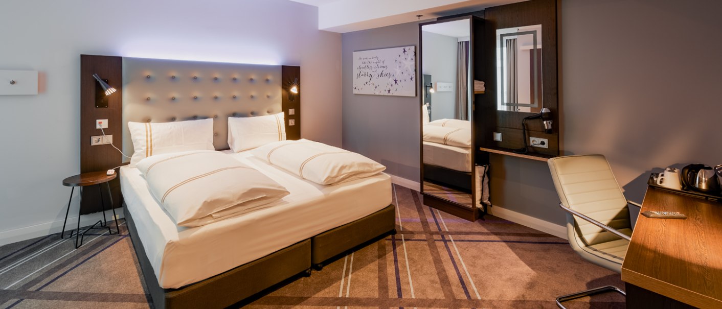 Modernes Hotelzimmer mit Doppelbett, Schreibtisch, Stuhl und Wasserkocher. Das Zimmer ist behindertengerecht gestaltet., © Premier Inn