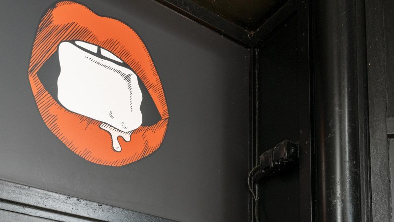 Illustration von roten Lippen mit einem Eisw&uuml;rfel auf schwarzem Hintergrund. Die Umgebung ist dunkel und industriell gestaltet., &copy; Stuttgart Marketing GmbH, Sarah Schmid