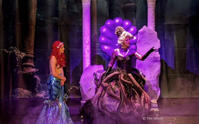 Zwei Darstellerinnen in einem Theaterstück: Eine als Meerjungfrau mit rotem Haar, die andere als Meereshexe mit Tentakeln, auf einer Bühne mit mystischem Hintergrund., © Kultur- und Sportamt Stadt Bietigheim-Bissingen