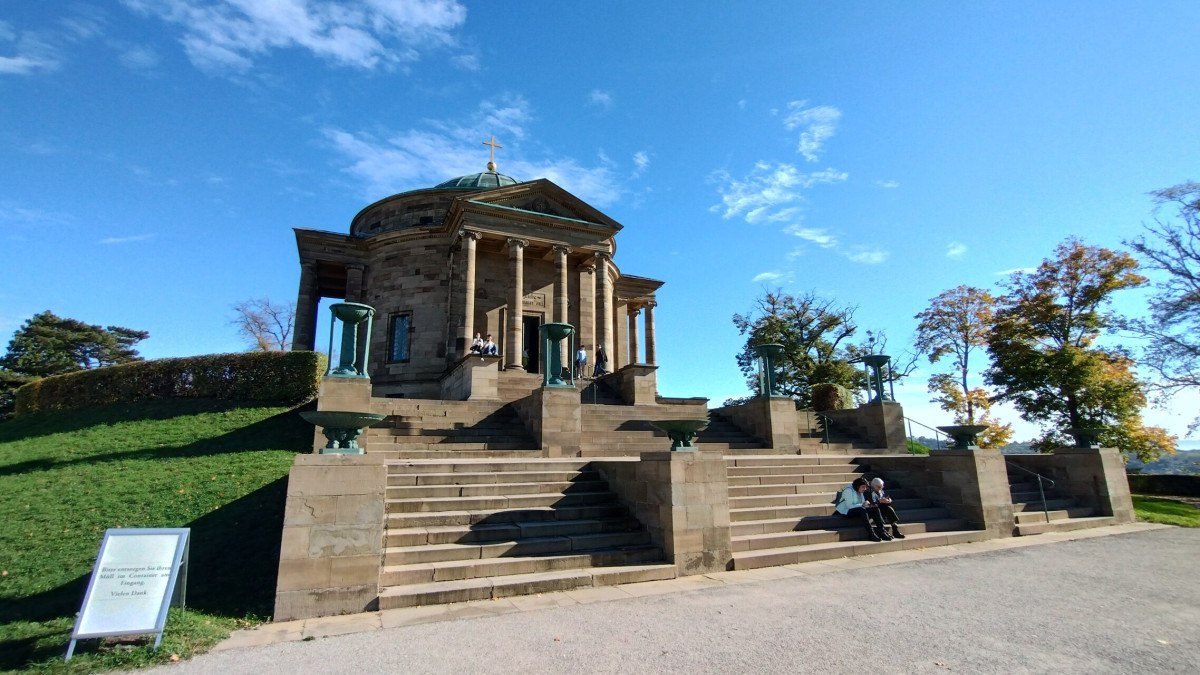 Die Grabkapelle auf dem Rotenberg mit breiten Treppen und Personen, die auf den Stufen sitzen. Der Himmel ist klar und sonnig. Die Grabkapelle auf dem Rotenberg mit breiten Treppen und Personen, die auf den Stufen sitzen. Der Himmel ist klar und sonnig.