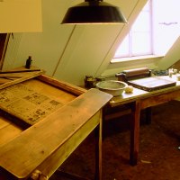 Historische Druckwerkstatt im J.-F.-Schreiber Museum Esslingen mit Holztischen, Druckutensilien und einem Fenster im Hintergrund., © Esslinger Stadtmarketing & Tourismus GmbH