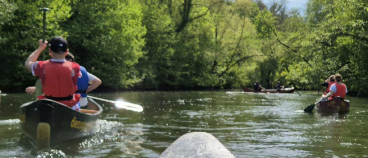 Eine Gruppe von Menschen paddelt in Kanus auf einem ruhigen Fluss, umgeben von &uuml;ppigem Gr&uuml;n und B&auml;umen., &copy; WTM GmbH Waiblingen