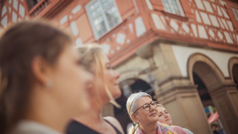 Eine Gruppe von Menschen steht vor einem historischen Fachwerkhaus in Waiblingen. Die Personen blicken interessiert in eine Richtung., &copy; WTM GmbH Waiblingen