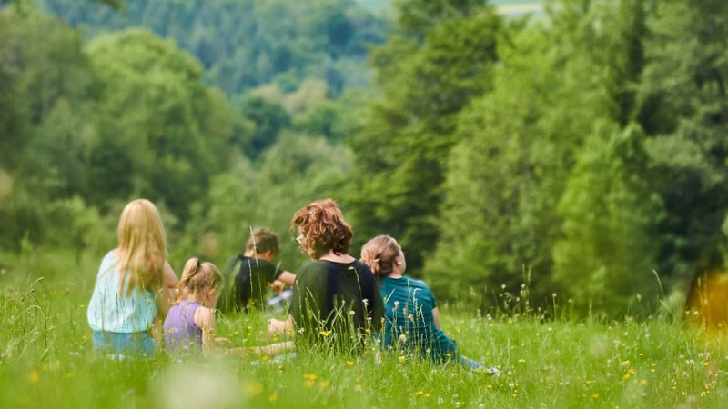 Menschen sitzen auf einer blühenden Wiese, umgeben von grünen Bäumen. Sie genießen die Natur in entspannter Atmosphäre., © Stadt Waldenbuch Menschen sitzen auf einer blühenden Wiese, umgeben von grünen Bäumen. Sie genießen die Natur in entspannter Atmosphäre., © Stadt Waldenbuch