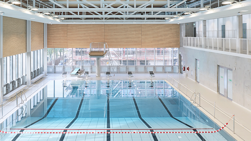 Modernes Schwimmbad mit Sprungturm, Startblöcken und großen Fenstern. Helle, offene Architektur mit Sicht auf Bauarbeiten draußen., © Stuttgarter Bäder