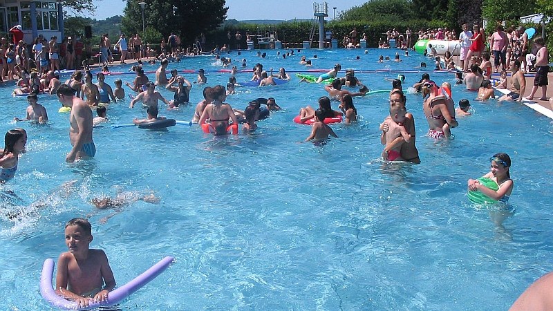 Viele Menschen genie&szlig;en einen sonnigen Tag im Freibad Renningen. Kinder und Erwachsene schwimmen und spielen im Wasser., &copy; Stadt Renningen