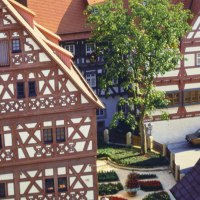 Fachwerkhäuser in Bietigheim-Bissingen, darunter das Hornmoldhaus. Ein Baum und ein Blumenbeet schmücken den Innenhof., © Stuttgart-Marketing GmbH Fachwerkhäuser in Bietigheim-Bissingen, darunter das Hornmoldhaus. Ein Baum und ein Blumenbeet schmücken den Innenhof., © Stuttgart-Marketing GmbH