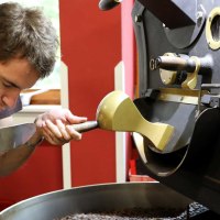 Ein Mann pr&uuml;ft den Duft von frisch ger&ouml;steten Kaffeebohnen in einer R&ouml;stmaschine. Er konzentriert sich auf das Aroma der Bohnen., &copy; EINS + Alles/Christopherus e. V.