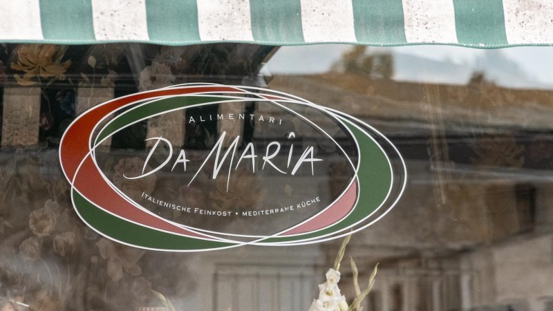Schaufenster mit dem Logo von "Alimentari Da Maria". Es zeigt italienische Farben und bietet italienische Feinkost und mediterrane K&uuml;che an., &copy; Stuttgart Marketing GmbH, Sarah Schmid