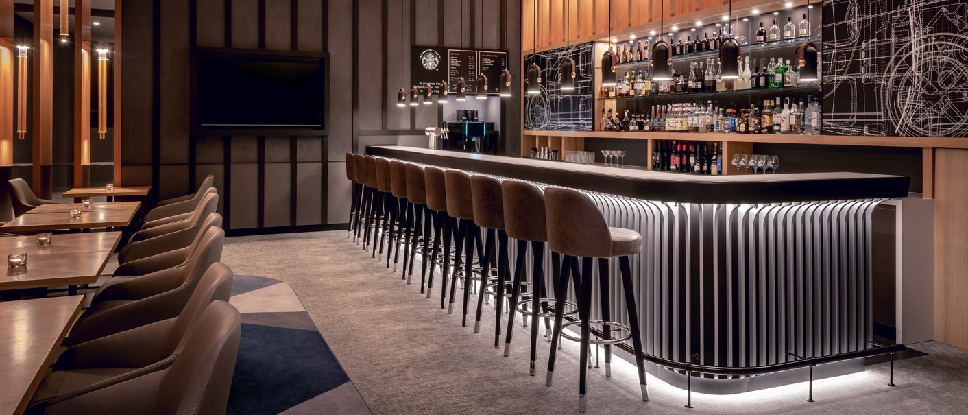 Elegante Bar mit langen Tresen, Barhockern und beleuchteten Regalen voller Flaschen. Moderne Einrichtung mit warmem Licht und stilvollen Details., &copy; Stuttgart Marriott Hotel Sindelfingen
