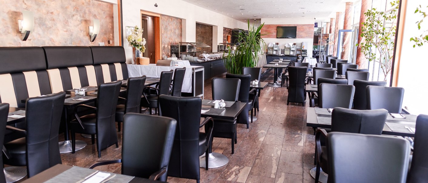 Modernes Restaurant mit schwarzen Stühlen, gedeckten Tischen und heller Einrichtung. Große Fenster lassen viel Licht herein., © Plaza Residence Stuttgart-Ditzingen Modernes Restaurant mit schwarzen Stühlen, gedeckten Tischen und heller Einrichtung. Große Fenster lassen viel Licht herein., © Plaza Residence Stuttgart-Ditzingen
