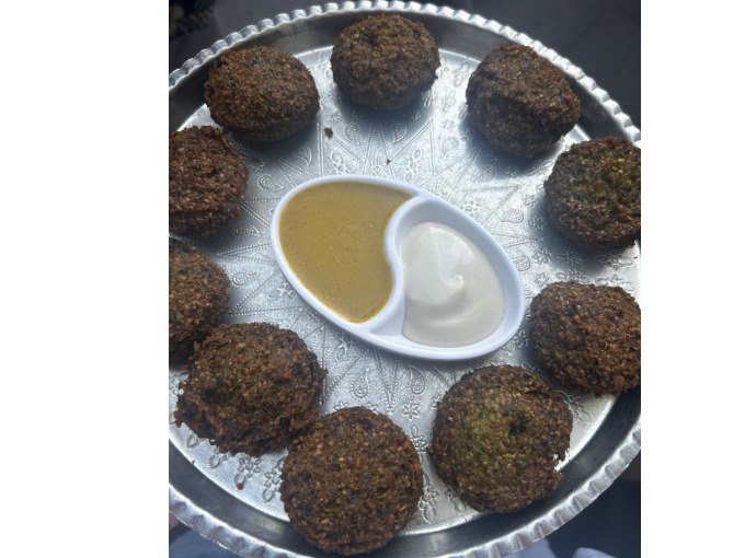 Ein silbernes Tablett mit Falafel-Kugeln und zwei Dips in der Mitte, serviert auf einem dekorativen Teller., © Cool-Tours StattReisen Ein silbernes Tablett mit Falafel-Kugeln und zwei Dips in der Mitte, serviert auf einem dekorativen Teller., © Cool-Tours StattReisen