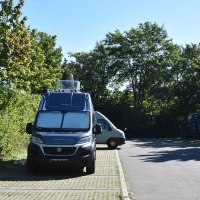 Wohnmobilstellplatz in B&ouml;blingen mit geparkten Wohnmobilen, umgeben von B&auml;umen und sonnigem Wetter., &copy; Stadtmarketing B&ouml;blingen e. V.