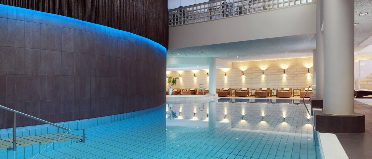 Moderner Hotelpool mit blauer Beleuchtung, Liegestühle im Hintergrund, stilvolle Architektur., © Hotel Le Méridien