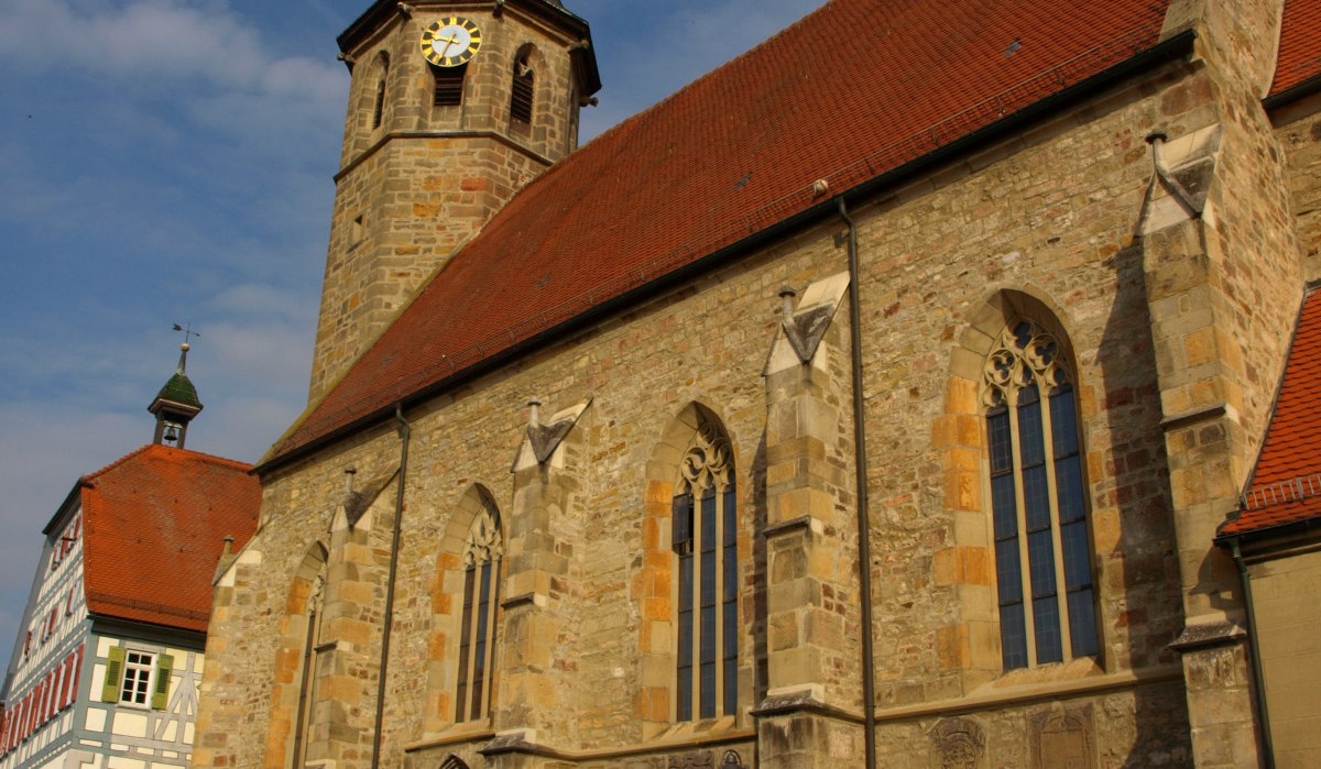 Die Evangelische Martinskirche mit gotischen Fenstern und einem Turm mit Uhr vor blauem Himmel., © Land der 1000 Hügel - Kraichgau-Stromberg