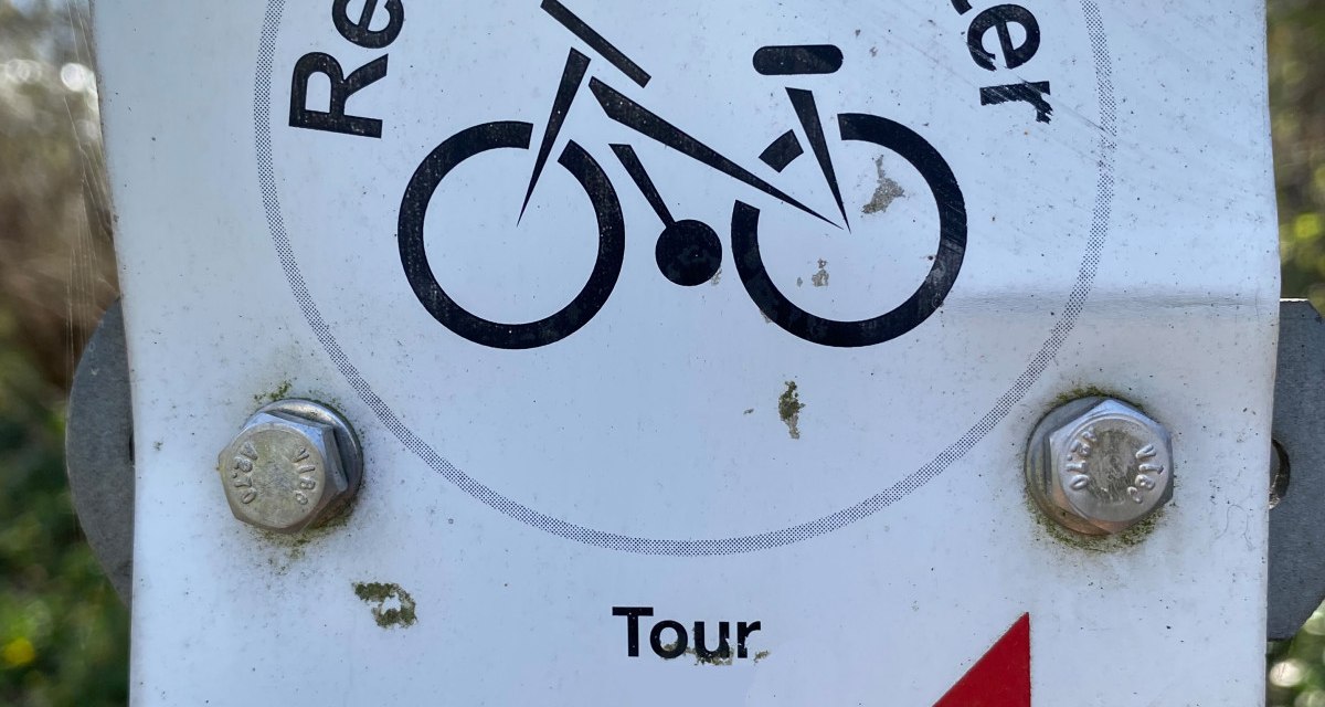 Schild mit 'Remseck-Achter', Fahrradsymbol, 'Tour 1' und rotem Pfeil nach links. Unten das Wappen von Remseck am Neckar. Schild mit 'Remseck-Achter', Fahrradsymbol, 'Tour 1' und rotem Pfeil nach links. Unten das Wappen von Remseck am Neckar.