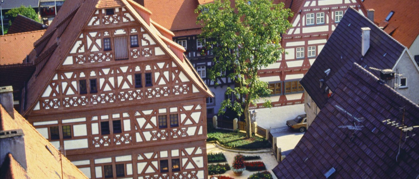 Fachwerkhäuser in Bietigheim-Bissingen, darunter das Hornmoldhaus. Ein Baum und ein Blumenbeet schmücken den Innenhof., © Stuttgart-Marketing GmbH Fachwerkhäuser in Bietigheim-Bissingen, darunter das Hornmoldhaus. Ein Baum und ein Blumenbeet schmücken den Innenhof., © Stuttgart-Marketing GmbH