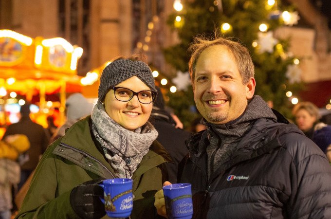 Zwei Personen genießen Glühwein auf einem festlich beleuchteten Weihnachtsmarkt in Nürtingen., © Stadt Nürtingen